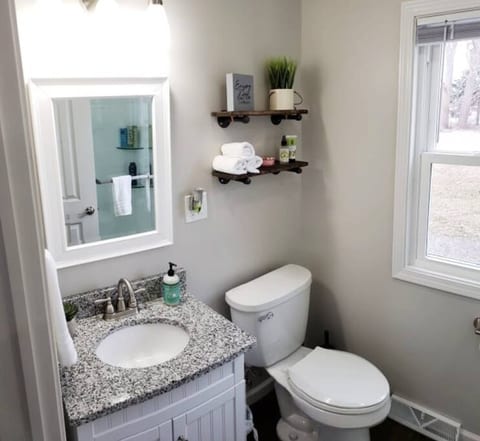 Our updated bathroom features a granite countertop and plenty of lighting.