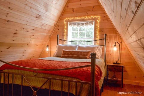 This bedroom is at the top of the steps to the left and overlooks the front yard. Relax under twinkle lights and beautiful pine walls.
