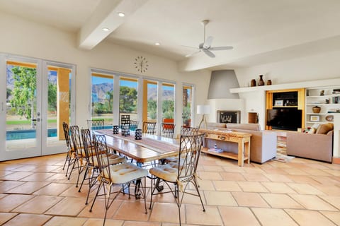 The bright and airy open-concept living and dining area is filled with natural light streaming through the expansive floor-to-ceiling windows.