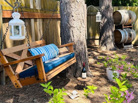 Outdoor Swing • This is a perfect place to kick off your shoes and read a book • Enjoy blue skies by day or starlit skies by night • Provides plenty of afternoon shade • Next to stacked barrels obtained from Domaine Serene • Relax and enjoy summer!