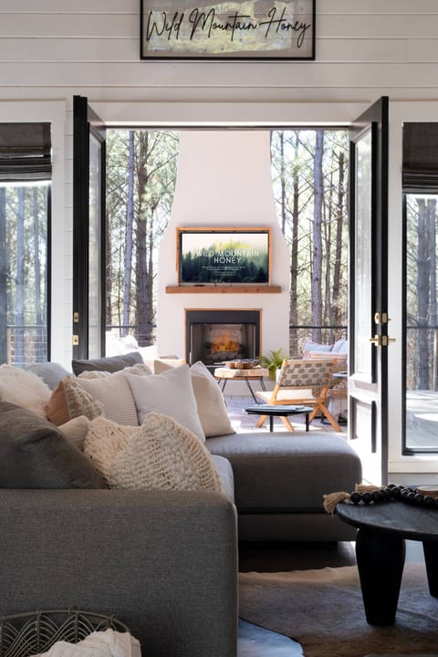 Bring the outdoors indoors in🪑 Plenty of seating & dining 🪟 Handy service window 🔥 Cozy fireplace & soothing hot tub 🌀 Built-in fans & Bluetooth speakers 🍔 Dual BBQ grill.
