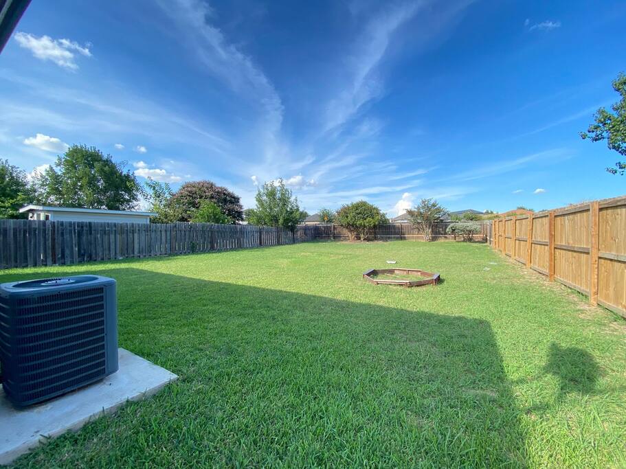 Relax and reconnect with nature in the expansive green backyard, ideal for enjoying sunny days and fresh air. - 4BR Family Oasis | Prime Location, Fast Wi-Fi-TCF - Converse