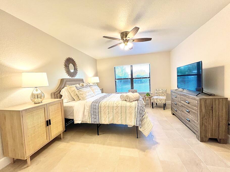 Relax in this cozy bedroom, complete with a large TV, ceiling fan, and plenty of natural light for a perfect retreat - 4BR Family Oasis | Prime Location, Fast Wi-Fi-TCF - Converse
