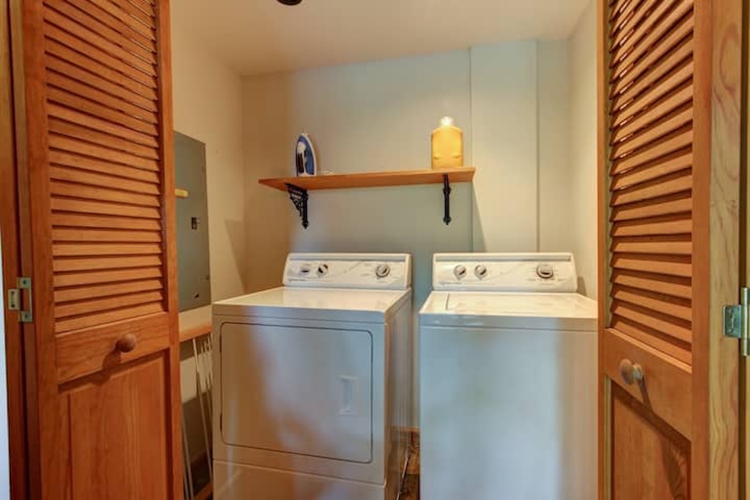Laundry area with iron and drying rack.