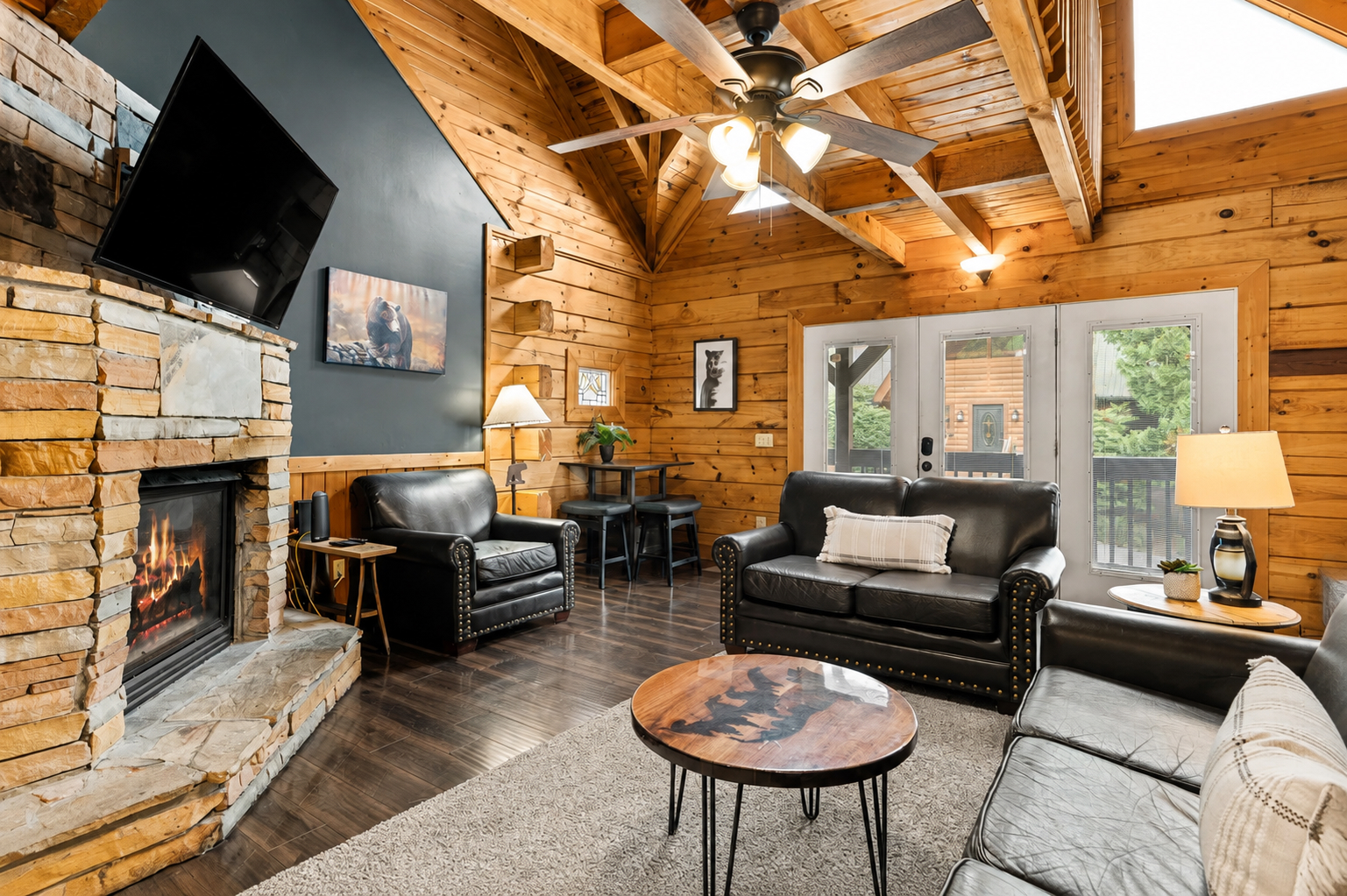 Gather by the stone fireplace in this warm, spacious great room with vaulted wood ceilings & Smart TV.