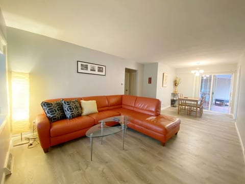 Spacious living room Area with comfortable Burnt Orange Italian Leather Couch. The couch faces a 42”TV.