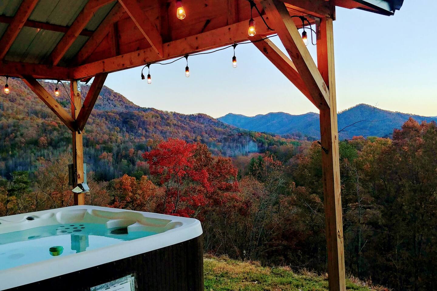 Private hot tub featuring warm ambient lighting and stunning mountain views — perfect for relaxing and enjoying the peaceful outdoors.