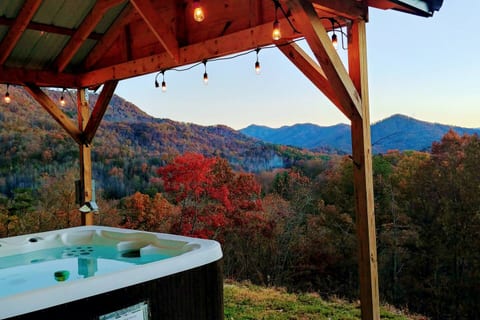 Private hot tub featuring warm ambient lighting and stunning mountain views — perfect for relaxing and enjoying the peaceful outdoors.