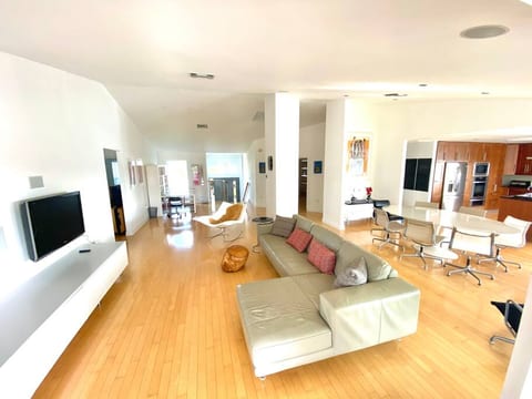 Living & dining room ; roku TV; guest bedrooms & bathroom to the left; master bedroom to the right (behind kitchen); steps to downstairs & front door in center of pic; private office space just to the right of that.