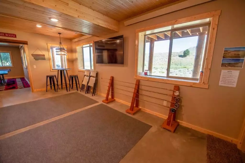 Bar area with 65" TV, rod holders (Fly rods not provided) and area for all your fishing gear. Concrete floors are perfect for changing inside in wet or dark conditions. Folding chairs to sit and put on and remove boots.