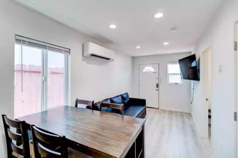 Open Concept Kitchen with Full Fridge/Freezer, Range Stovetop (Stove Only, NO OVEN), Air Conditioning (AC), Dining Table, 55" Wall Mounted Roku TV, Sofa (converts flat to full size bed) and Common Area Half-Bath