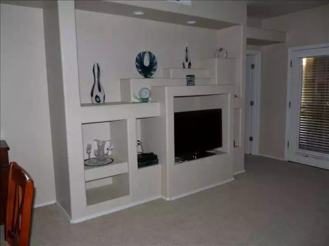 Entertainment unit in living room. Door to the right leads to the balcony.