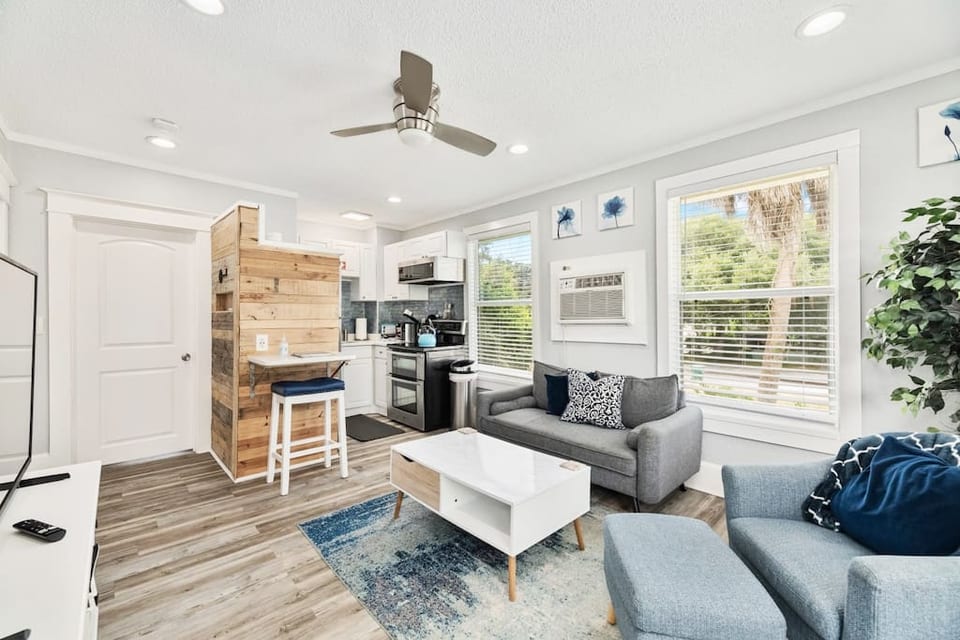 This is the living room and kitchen, as seen from the front of the unit. The entry door is to the left and the bedroom door is next to the pallet wall.