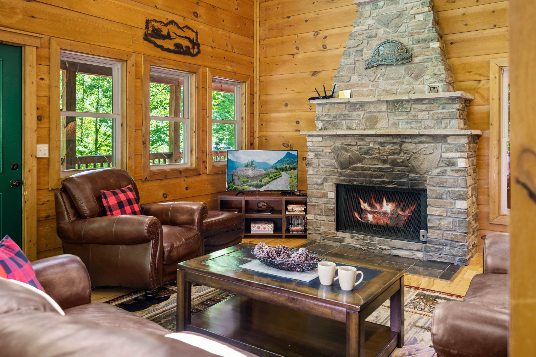 Spacious open living area that connects with the dining area & kitchen.  Tall ceilings with cathedral windows allow tons of natural light, and views of the woods.  Stone gas fireplace is available October-April only.