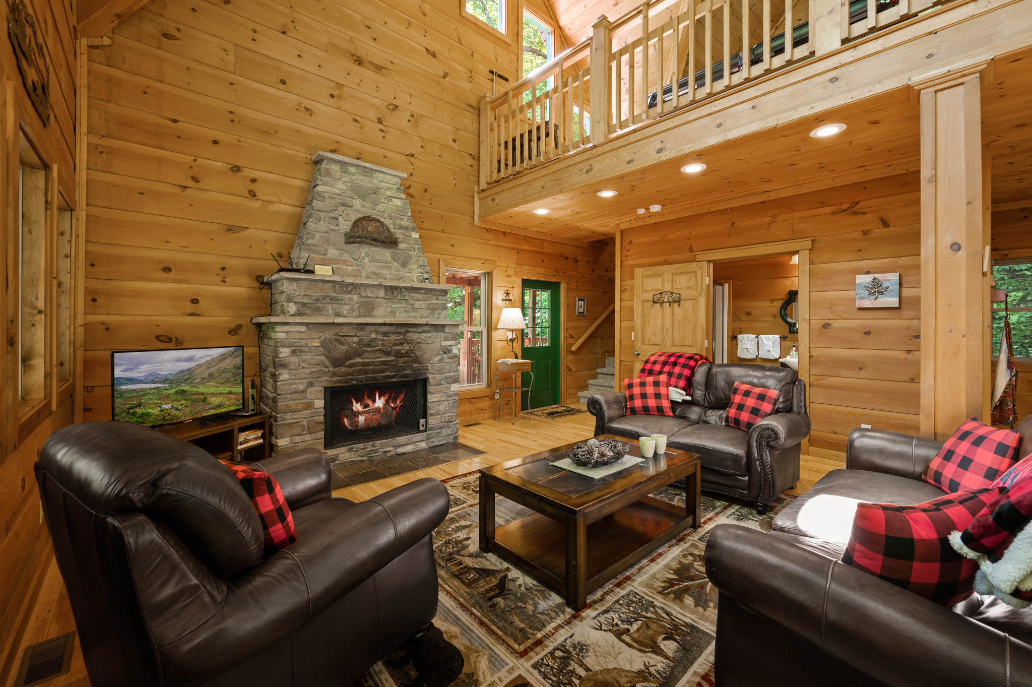 Spacious open living area that connects with the dining area & kitchen.  Tall ceilings with cathedral windows allow tons of natural light, and views of the woods.  Stone gas fireplace available for use October-April only.
