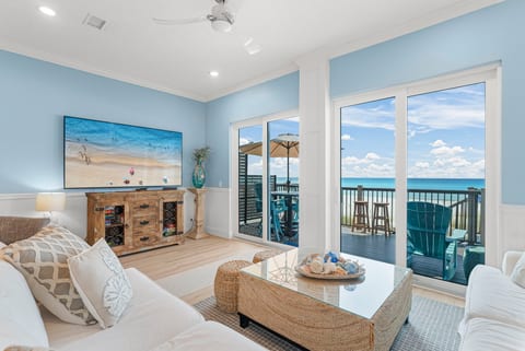 Step in: the first-floor living room opens to sweeping Gulf views. Plush seating + an 86-inch 4K TV + surround sound = movie nights with waves crashing outside.