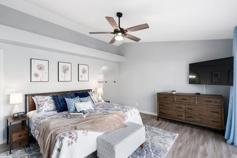 Primary w/King bed, nightstands, lamps, TV, cable, dresser, door to back patio.