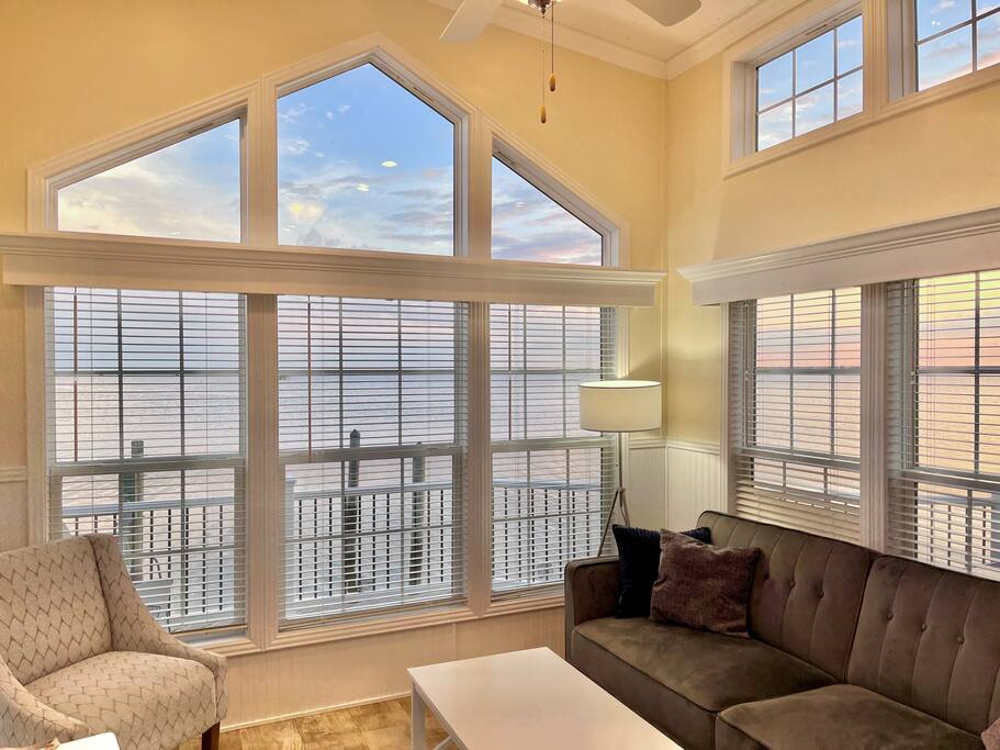 Watch the sun set over the bay, sweeping views of the Back Bay right from the couch!  (Note that we have replaced this couch with the blue one in other photos.)