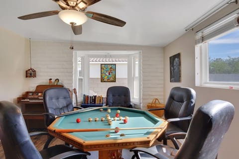 We've designed this house specifically for company and family groups to spend time together. Here's a bumper pool table under the poker table. There's a piano and guitar as well.