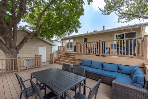 Spacious shaded deck with outdoor dining, lounge seating, and grill