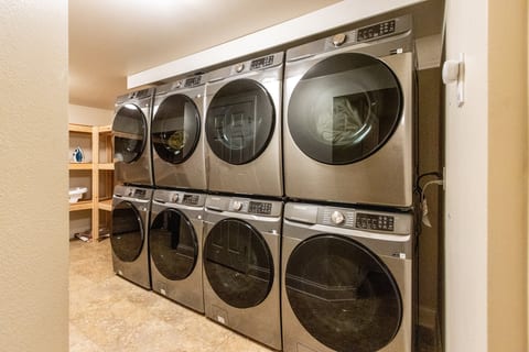 Spacious laundry room with multiple modern washers and dryers