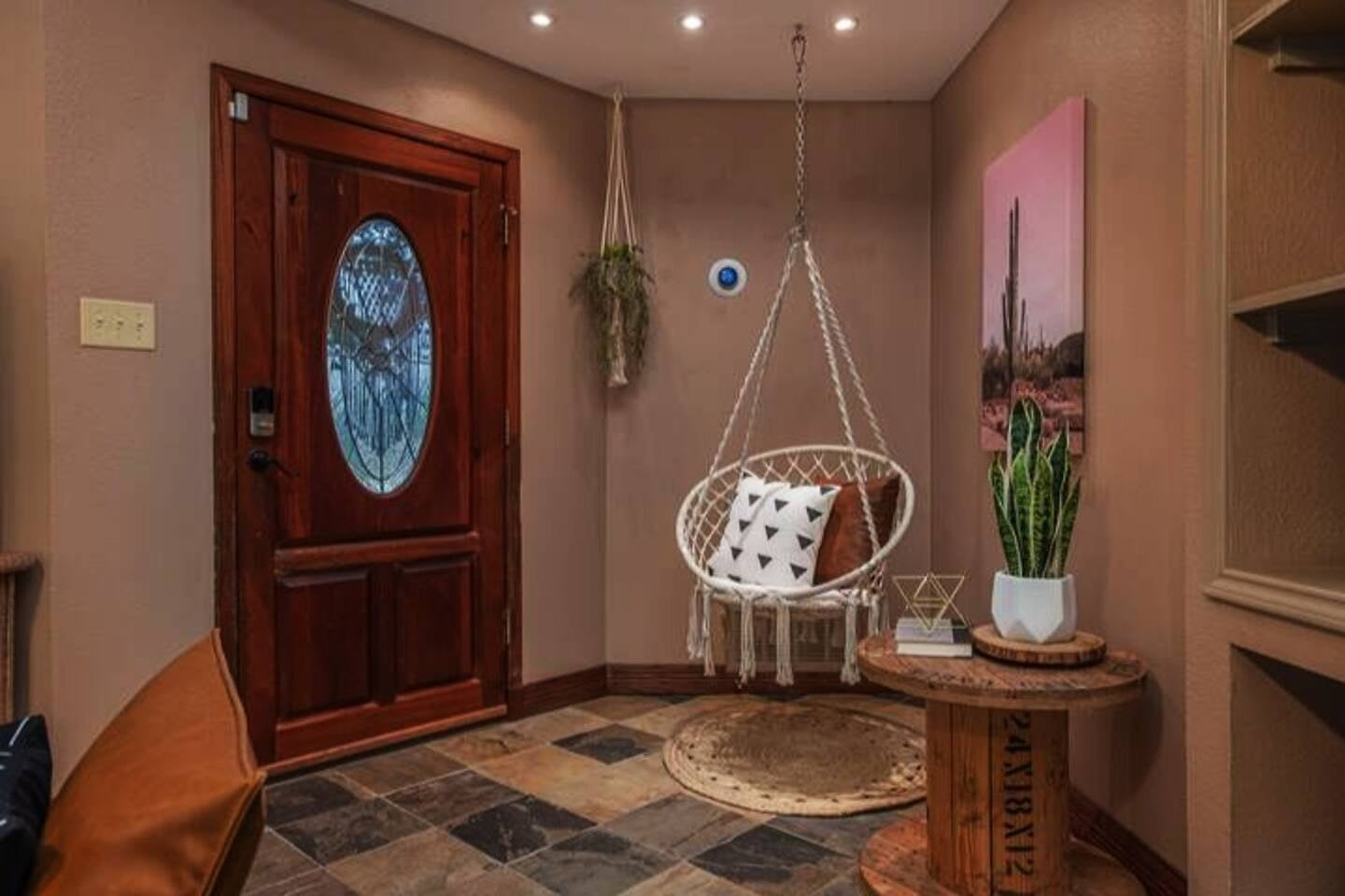 Relax in this unique living room with a cozy swing and stunning scenic wall art that adds a touch of tranquility