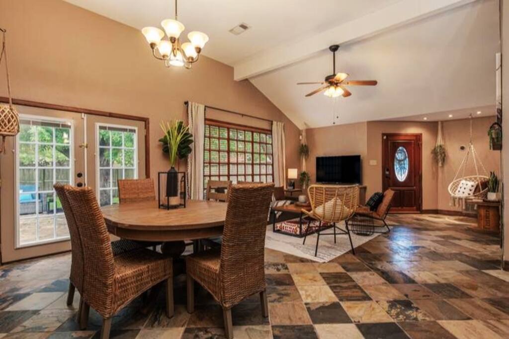 A perfect mix of comfort and style, this living room boasts a sofa, ceiling fan, large window, TV, and warm decorative lighting
