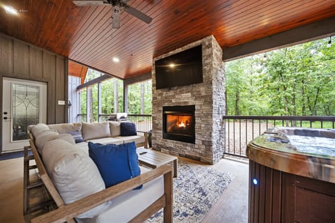 Outdoor living area with fireplace, grill, and 60" TV
