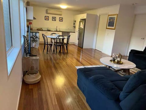 Large living area including lounge, dining table, television and kitchen