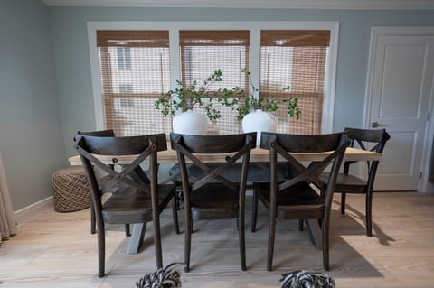 Enjoy rustic charm with wooden chairs, cozy decor, and natural light in this inviting dining space.