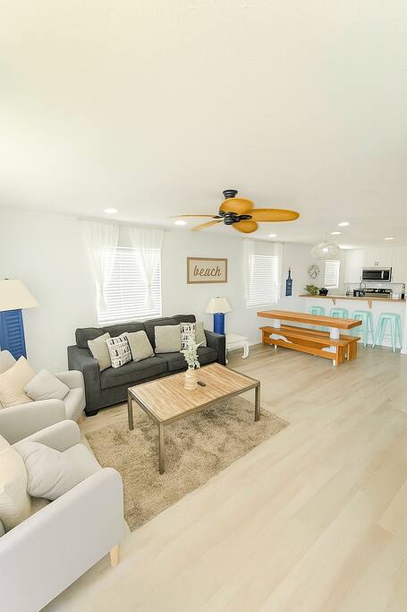 Living room featuring a sofa, a TV, a ceiling fan, a dining table, and bunk beds. Fall break Free golf cart! 5 minutes walk to Beach