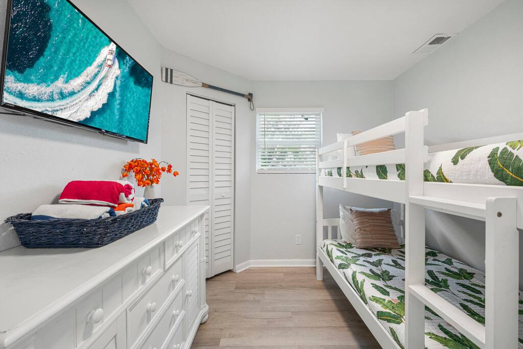 Cozy bedroom with twin-size bunk beds featuring TV.