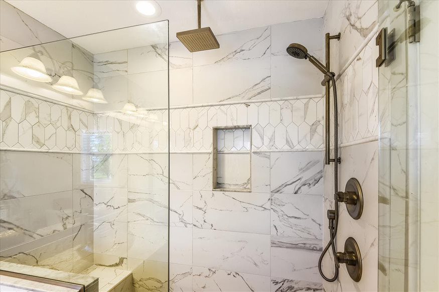 A white marble-themed shower that exudes a sense of luxury and elegance.