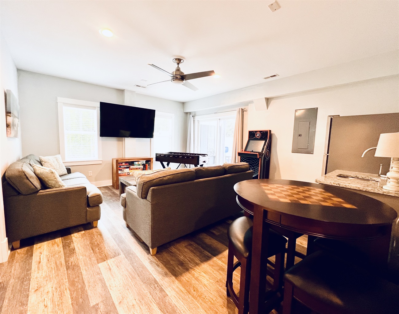 A lively game room awaits with a foosball table, comfy sofas, and a sleek wooden floor.