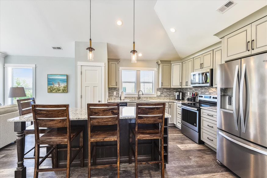 A tasteful off-white kitchen with a dining table, perfect for both cooking and sharing meals.