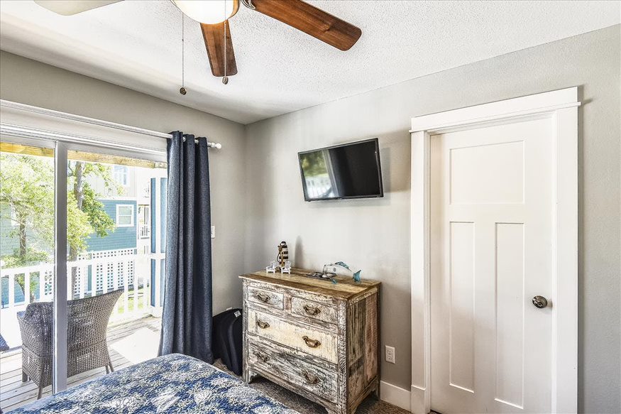 The other side of the room, opposite the bed, showcases a wall-mounted TV for entertainment.