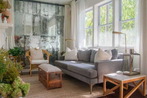 This stylish and serene living room, with an antiqued wall of mirrors, is where you'll want to be with friends or cozy up and read a book or watch a show.