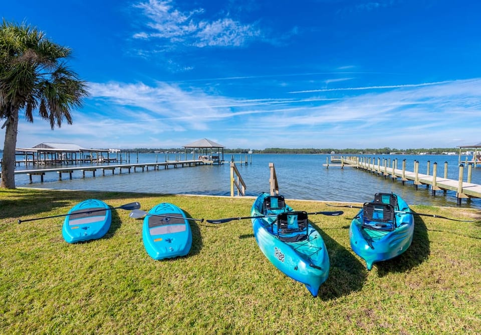 Tranquil lakeside escape: kayak and paddleboard adventures await under clear blue skies!