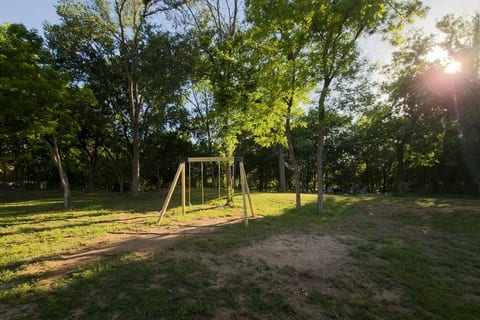 Experience double the fun with our backyard swing! Set against a backdrop of lush greenery and nestled on soft mulch padding, it's the perfect spot for relaxing and enjoying the outdoors with loved ones.
