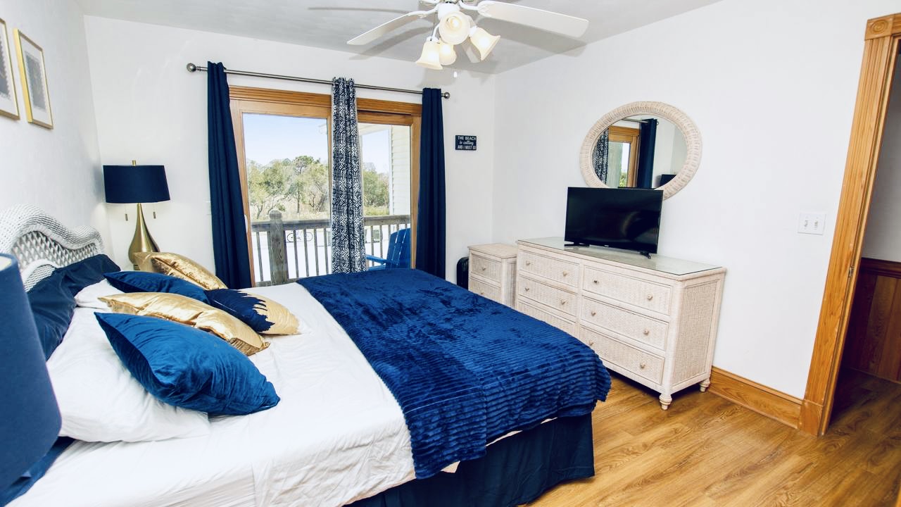 Stylish bedroom with a serene blue and white theme, complete with a Smart TV.