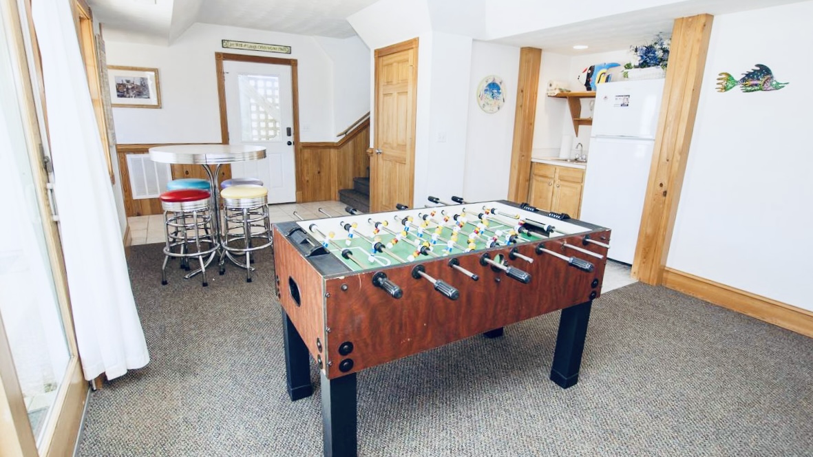 Recreation area with a foosball table on a carpeted floor.