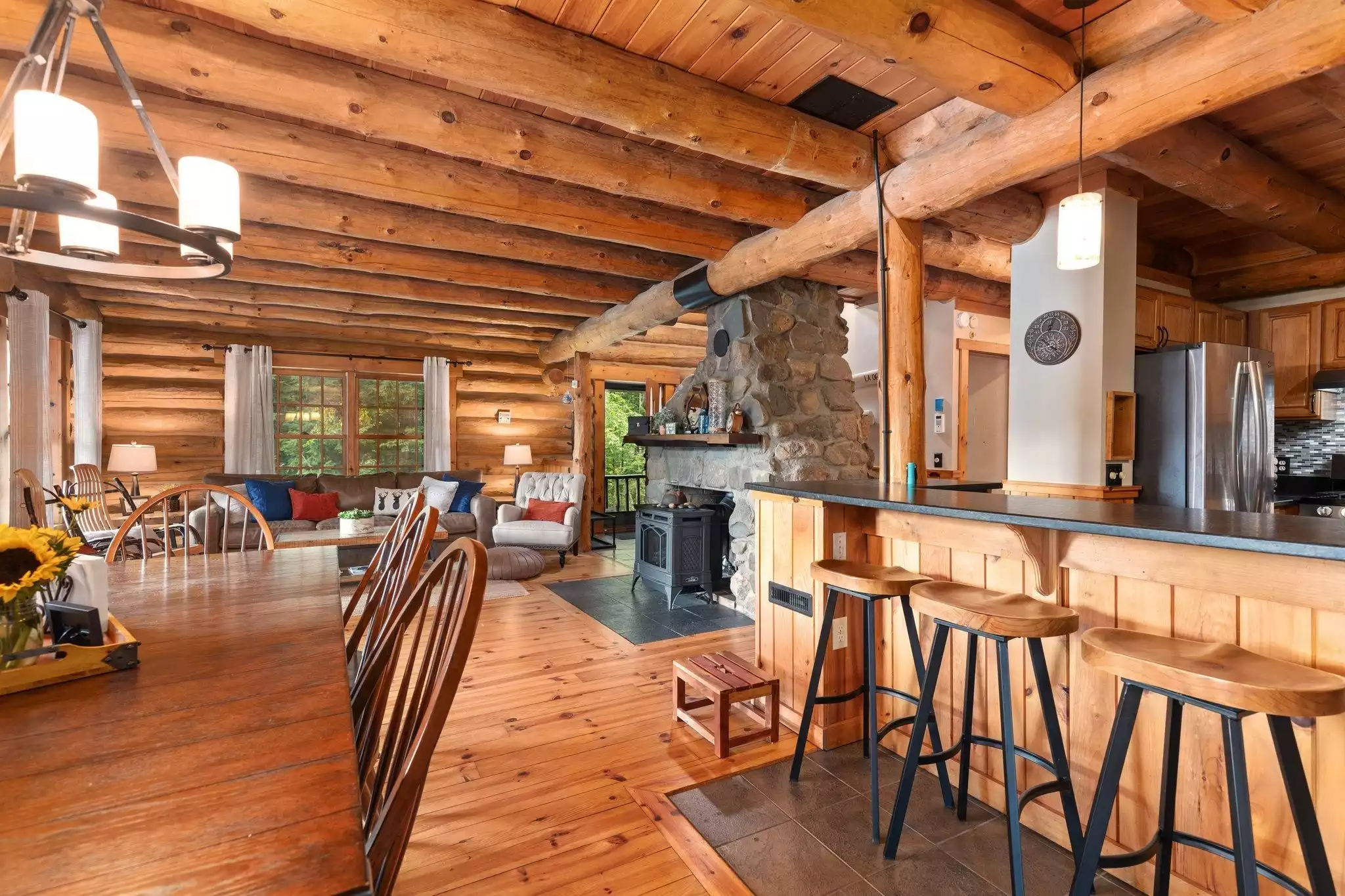 Dining area (table seating for eight) plus breakfast bar - Kane Cabin Log Home w/beach on Baxter Lake, NH - Farmington