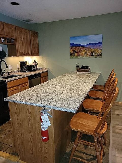Kitchen with granite countertops, kitchen island, fridge, stove, microwave, dishwasher, toaster, and 2 coffee makers (Keurig and regular)