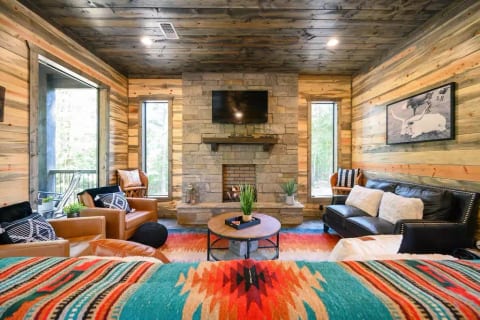 Relax around the big TV and indoor fireplace on comfy couches and chairs with cozy blankets and enjoy the vibrant modern southwest rugs and blankets! The couch is great for a quick nap between the fun activities in Broken Bow!