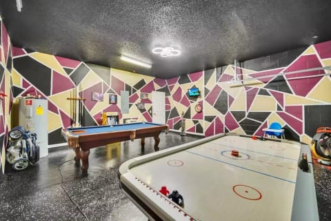 The Game room where you can play a game of pool on the refurbished pool table. There is a packman arcade with over 20 different style gaming options. Also and air hockey table and a tv to enjoy.