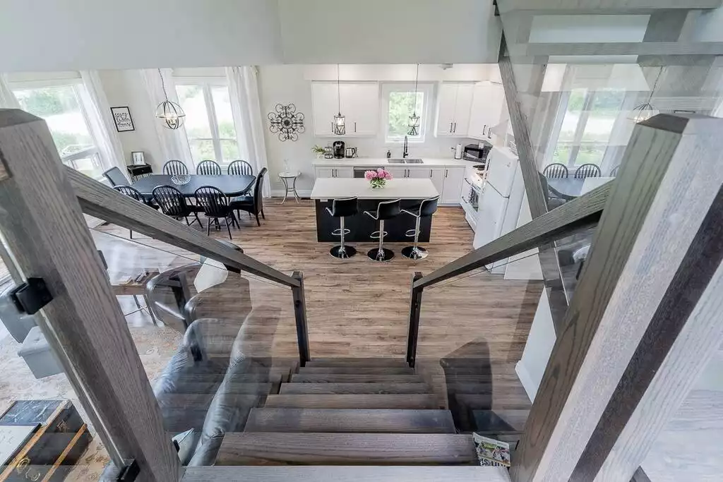 View of the main floor great room from the glass staircase landing. - Lake View 4 Bdrm, King Size Bed, Games Room - Innisfil