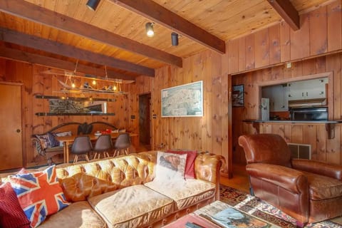The open plan living and dining room with 8 seat table and antique handmade ski light fixture make Kilbourne Lodge a perfect place to both entertain and relax.
