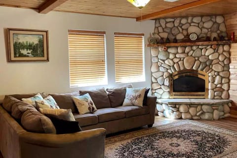 Cozy living room with fireplace, smart tv, and comfortable sofabed.