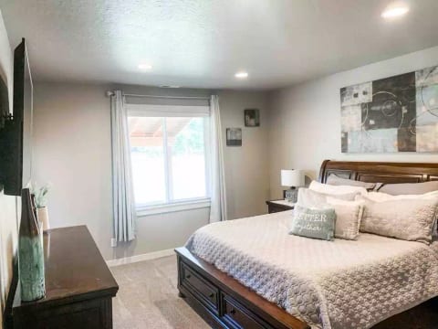 Main Level Master Bedroom features king size bed, 2 nights stands on each side, dresser, and a large screen TV.