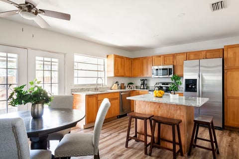 Kitchen and dining area with stocked cooking pots, pans, and utensils.